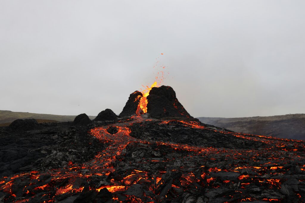 Vulcano islandese in eruzione, con fiumi di lava incandescente che scorrono lungo il fianco della montagna.